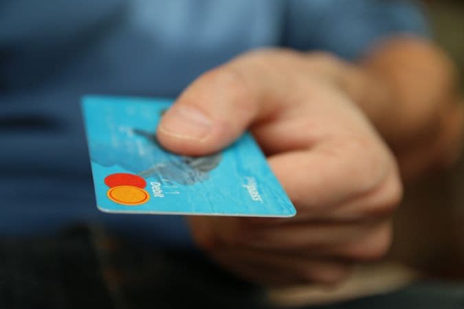 Credit card and coins on a desk representing everyday bank charges