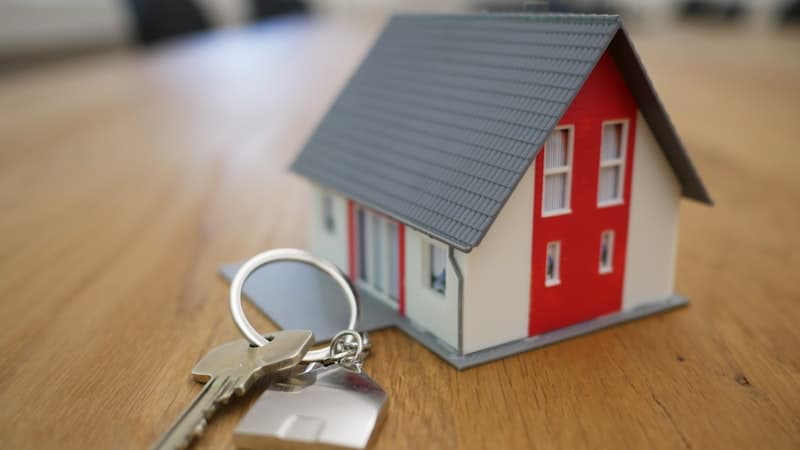 Homeowner reviewing mortgage documents and house keys on a desk