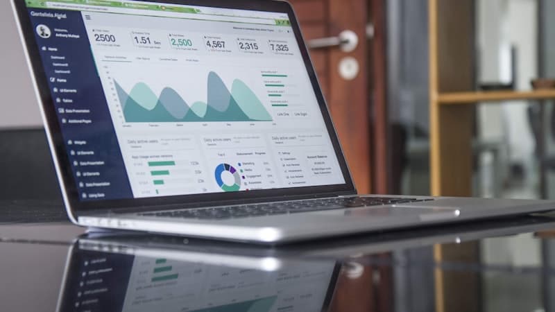 Person comparing financial options on a laptop with charts and notes